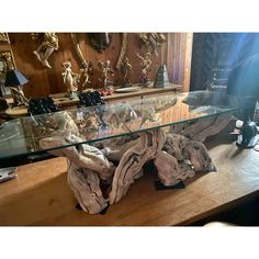 a glass table with driftwood on it in front of a mirror and other items