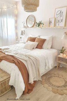 a bedroom with white walls and wooden flooring is decorated in neutral tones, such as beige