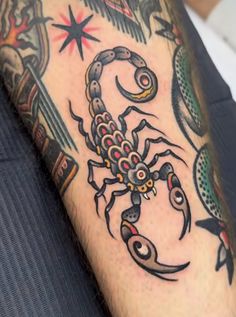 a man's arm with a tattoo on it and a scorpion in the middle