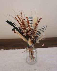 a vase filled with dried flowers on top of a table