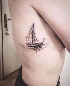 a black and white photo of a sailboat on the back of a woman's thigh