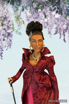 a barbie doll dressed in a red dress and holding a cane with purple flowers behind her