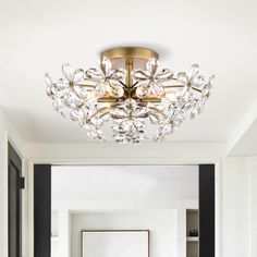 a chandelier hanging from the ceiling in a room with white walls and black trim