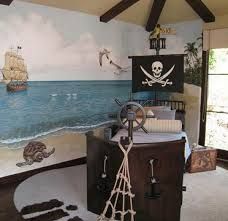 a bedroom with a pirate theme painted on the wall and ship in the ocean behind it