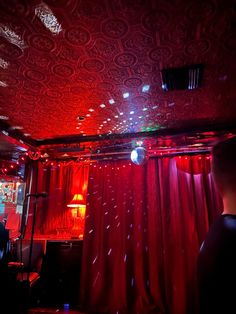 a room with red curtains and lights on the ceiling