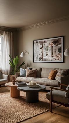 a living room filled with furniture and a large painting on the wall above it's coffee table