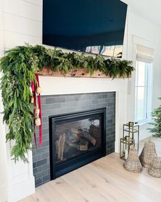 a fireplace decorated with greenery and christmas decorations