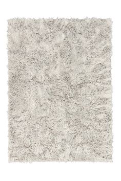 a white rug with shaggy edges on the top and bottom corner, in various shades of grey