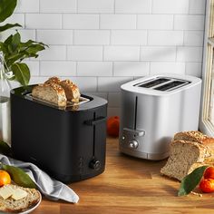 two slices of bread sit in front of an electric toaster on a wooden table