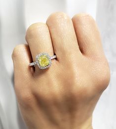 a woman's hand with a yellow and white diamond ring