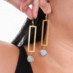 Catch some beach vibes with our Sandy Beaches Earrings! These blue and gold beauties feature a fun ocean print and a long rectangle charm. Perfect for adding a touch of seaside charm to any outfit. Due to the handmade nature of this product, no two earrings are exactly the same. Product Details 3.5" long x 0.75" wide Gold plated french hooks, nickel free Raw brass charm Gold plated pendant tray Glass cabochon Cotton fabric Care Instructions Keep earrings dry, remove when cleaning or near water. Clean with a soft cloth. Store in a dry, enclosed container. Handmade Fabric Earrings, Two Earrings, Cloth Store, Beach Earrings, Magnetic Earrings, Fabric Earrings, Gold Beauty, Coffee Sleeve, Ocean Print