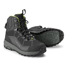 a pair of gray hiking boots with black laces on the outs and green accents