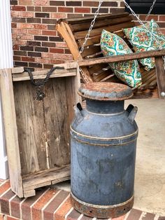 an old blue bucket sitting on top of a brick porch next to a wooden crate