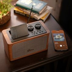 a wooden radio sitting on top of a table next to a cell phone