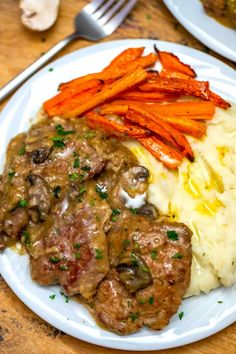 a white plate topped with meat, mashed potatoes and carrots