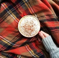 a person holding a cup of coffee on top of a blanket with the words hello november