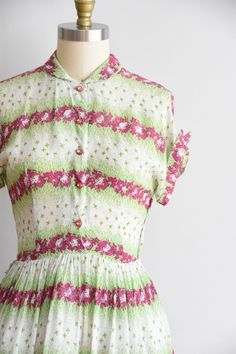 "Vintage 1950s daydress. Semi sheer nylon with fuschia & lime green floral print. Peter pan collar, capped fold over sleeves, and nipped waist. Semi full skirt. Side metal zipper and front button closure. State of garment | very good, light over all, and a tiny mend near waistline. Measurements ✂--- best fit | Medium bust | up to 36\" shoulders | not specified shoulder to waist | 16\" sleeves | not specified waist | 27 - 27.5\" hips | free total length (shoulder to hem) | 43.5\" tag | none p 1950s Garden, Happy Dresses, Dirndl Dress, Peach Dress, Green Floral Print, Different Dresses, Pan Collar, Metal Zipper, Peter Pan Collar