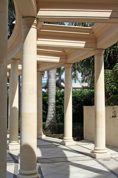 an outdoor area with columns and palm trees