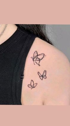 the back of a woman's shoulder with three butterflies on it