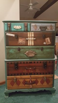 an old dresser is painted green and brown