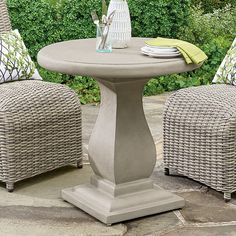 an outdoor table with chairs around it and plants in the backgroung area