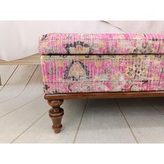 an upholstered bench with pink and yellow fabric