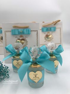 three small jars filled with candy and blue ribbon