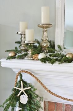 a christmas mantle with candles and ornaments on it, along with a starfish ornament