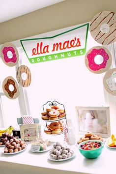 a table topped with donuts next to a window