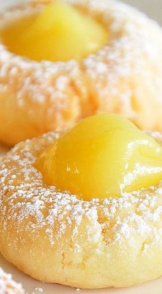 two pastries covered in powdered sugar with lemons on the top and bottom