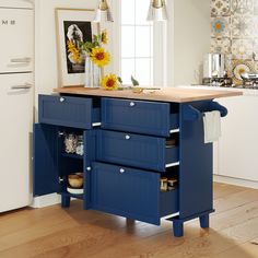 a blue kitchen island with drawers in the middle and sunflowers on it's side