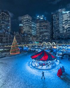 a christmas tree is lit up in the middle of a city