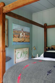 a bedroom with a bed and painting on the wall