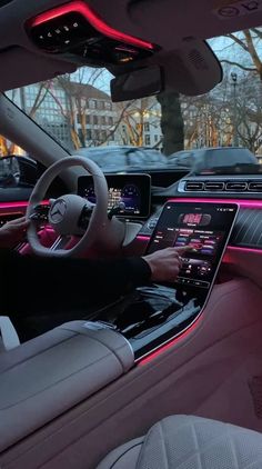 the interior of a car with pink lights and electronic controls on it's dashboard