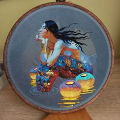 a blue plate with an image of a mermaid sitting on top of two gold fish