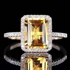 a yellow and white diamond ring with diamonds around it