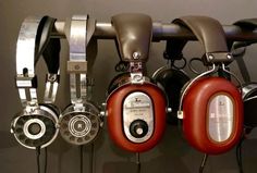 headphones are hanging on the wall in front of other headphones and earbuds