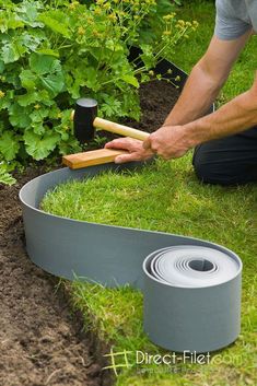 a man is working in the garden with gardening tools and tape on the ground next to his lawn