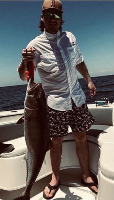 a man on a boat holding a fish