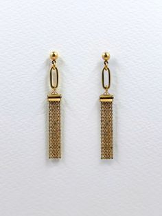 These earrings feature a delicate tassel of tiny, faceted brass chain beads.  The long, narrow length of the tassel combined with straight cut edge give these earrings a modern aesthetic.  An elongated, thick cut golden brass oval sits above further adding to the contemporary, geometric design.  The fine chain drapes and moves gently, shimmering softly as it reflects the light.  The simplicity of the forms and elements creates minimalistic, understated and elegant earrings that can easily worn everyday or evening.  The earrings are finished with a solid brass ball stud with stainless steel earring post.  Approximate measurements- 6cms long 1cm wide  All Set Theory jewellery comes with care instructions and a polishing pad to keep your earrings looking shiny and fabulous! ✨ Minimalist Gold Earrings, Set Theory, Gold Chain Earrings, Gold Chandelier Earrings, Minimalist Earrings Gold, Dangle Earrings Gold, Gold Dangle Earrings, Earring Post, Earrings Geometric