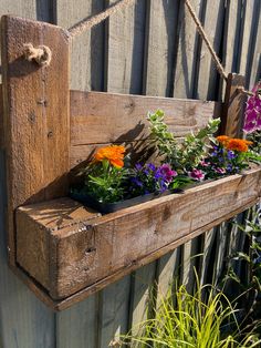 a wooden planter filled with lots of flowers