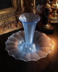 a blue glass vase sitting on top of a wooden table