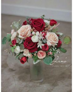 a bouquet of red and white roses in a vase on the floor with text that reads jane's floral design