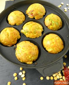 several muffins in a pan with corn on the side