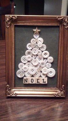 a christmas tree made out of buttons with the word noel spelled on it in a gold frame