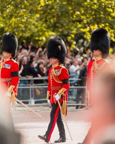 two men in red uniforms walking down the street