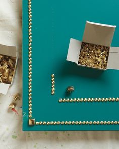 an open box with gold nuggets in it sitting on a table next to other items