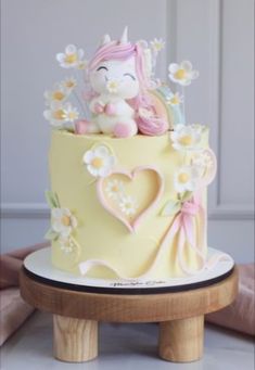 there is a small cake with flowers and a unicorn on it