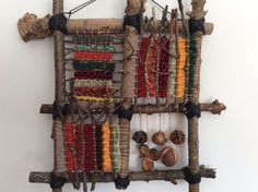 an art piece made out of sticks and other items on display in front of a white wall