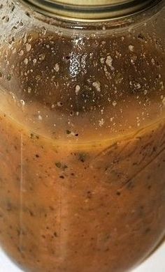 a jar filled with brown liquid sitting on top of a table